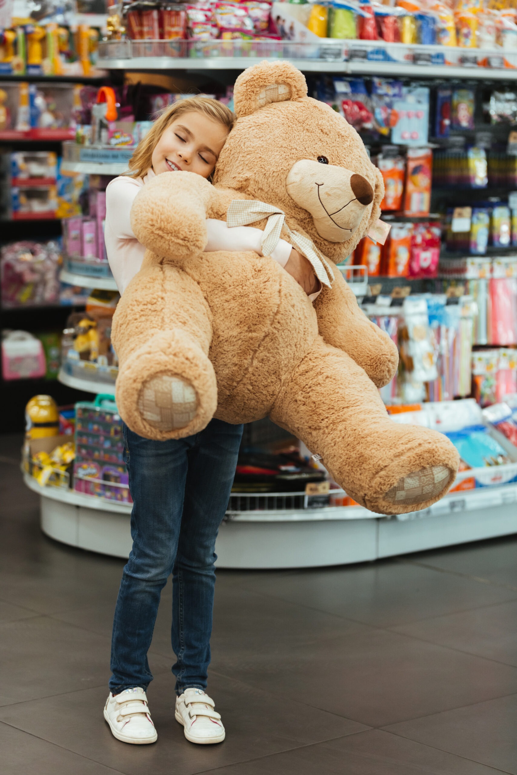 Delighted Little Girl Holding Big Teddy Bear
