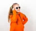 little-girl-orange-hoody-sunglasses-emotions-joy-sunny-day-portrait-white-background